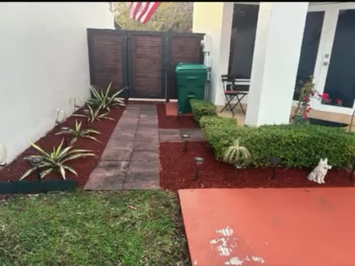 Finished landscaping walkway with red mulch and plants